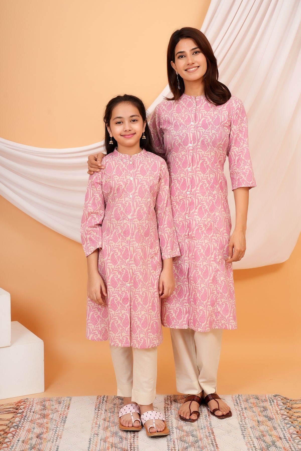 Mother and daughter in matching pink paisley kurtis