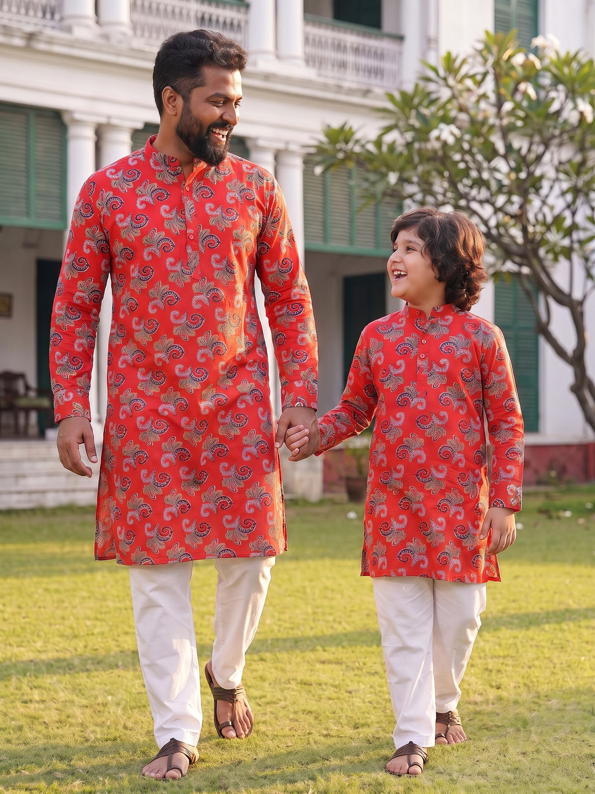 Father and son walking hand in hand in red kurtas