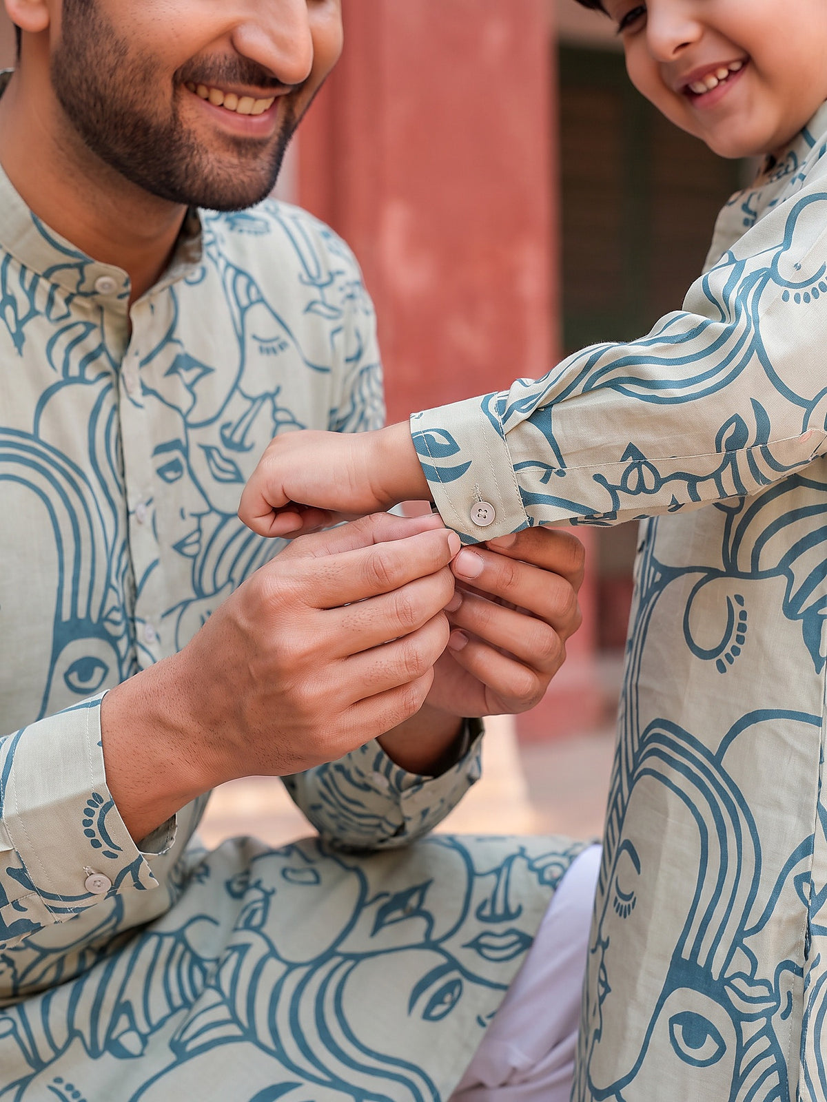 Close-up of buttoned cuff and face art print
