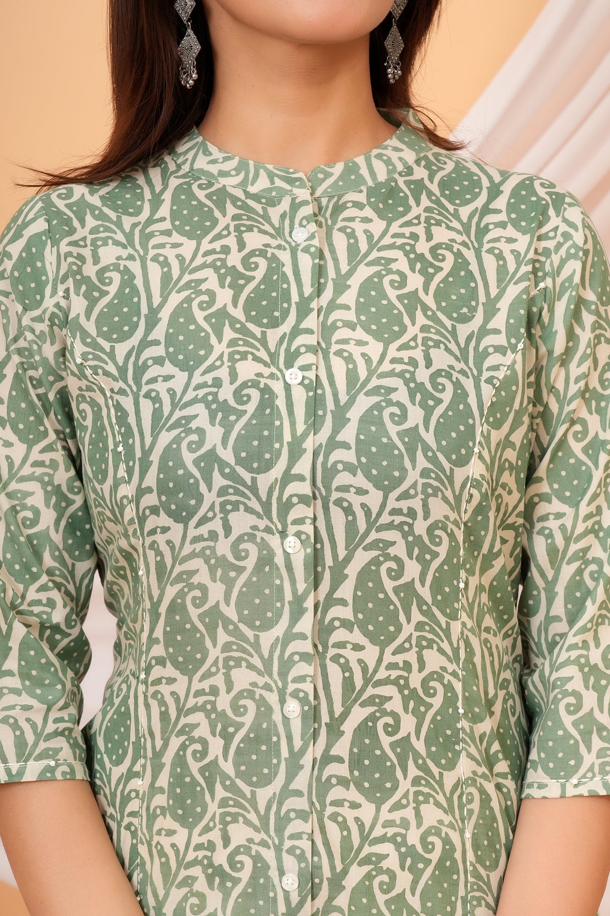 Close-up of the mandarin collar and sage green paisley print