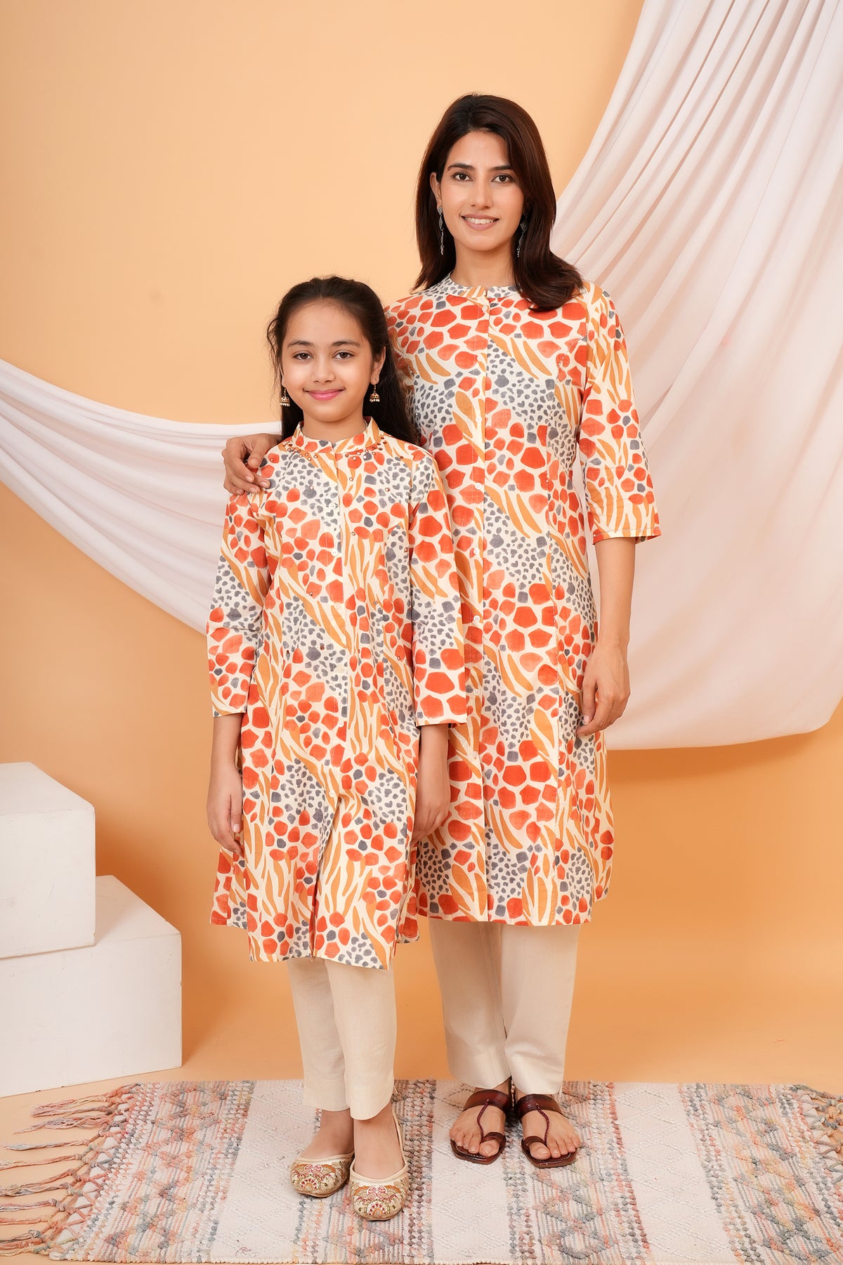 Maa and Beti in matching orange abstract animal printed kurtis