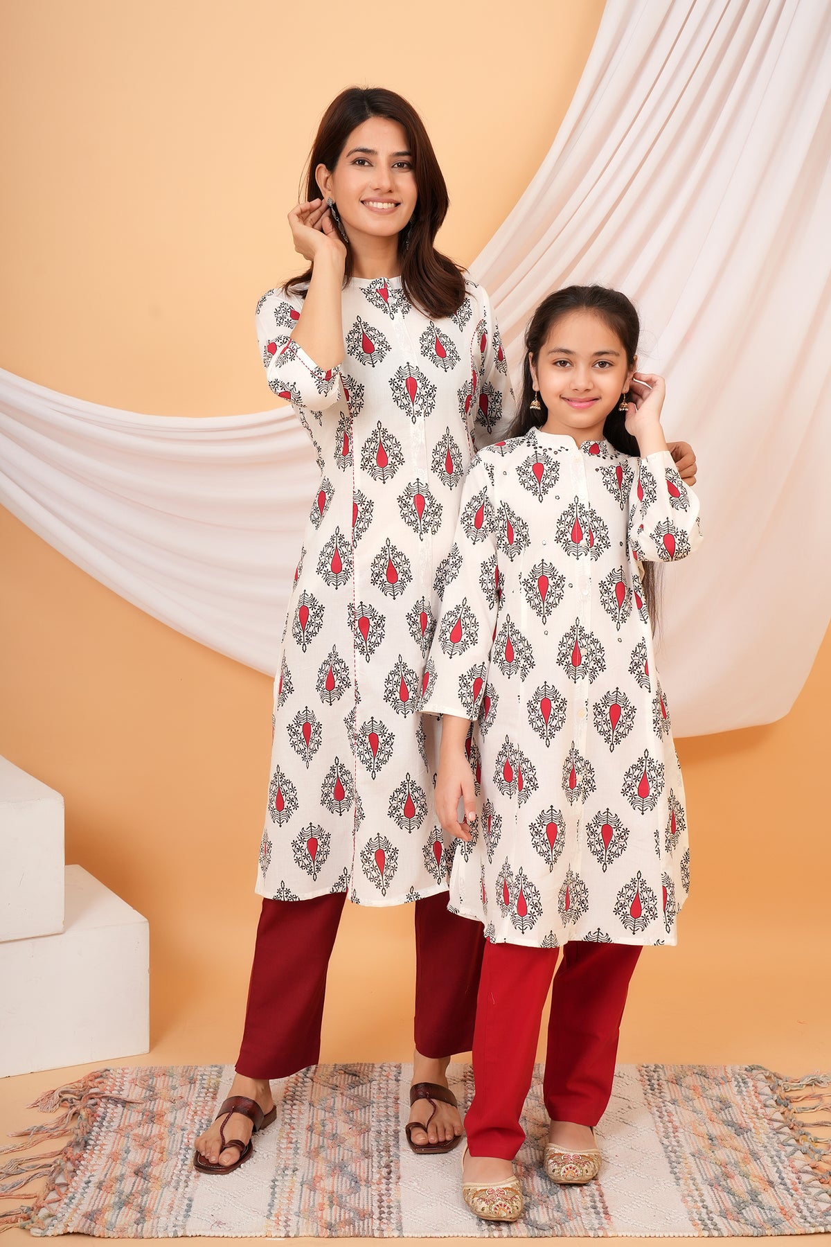 Maa and Beti in matching white kurtis with red buta print