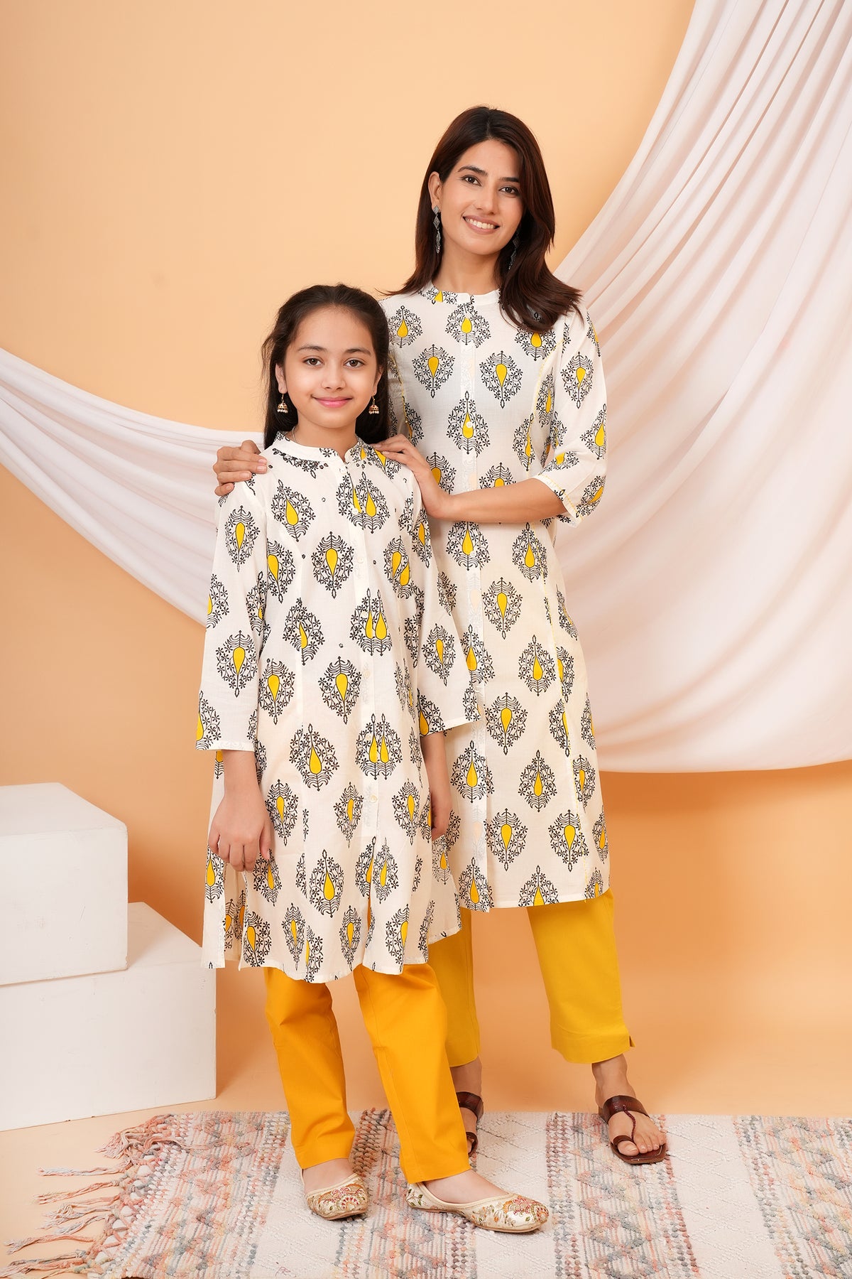 Maa and Beti in matching white kurtis with yellow buta print