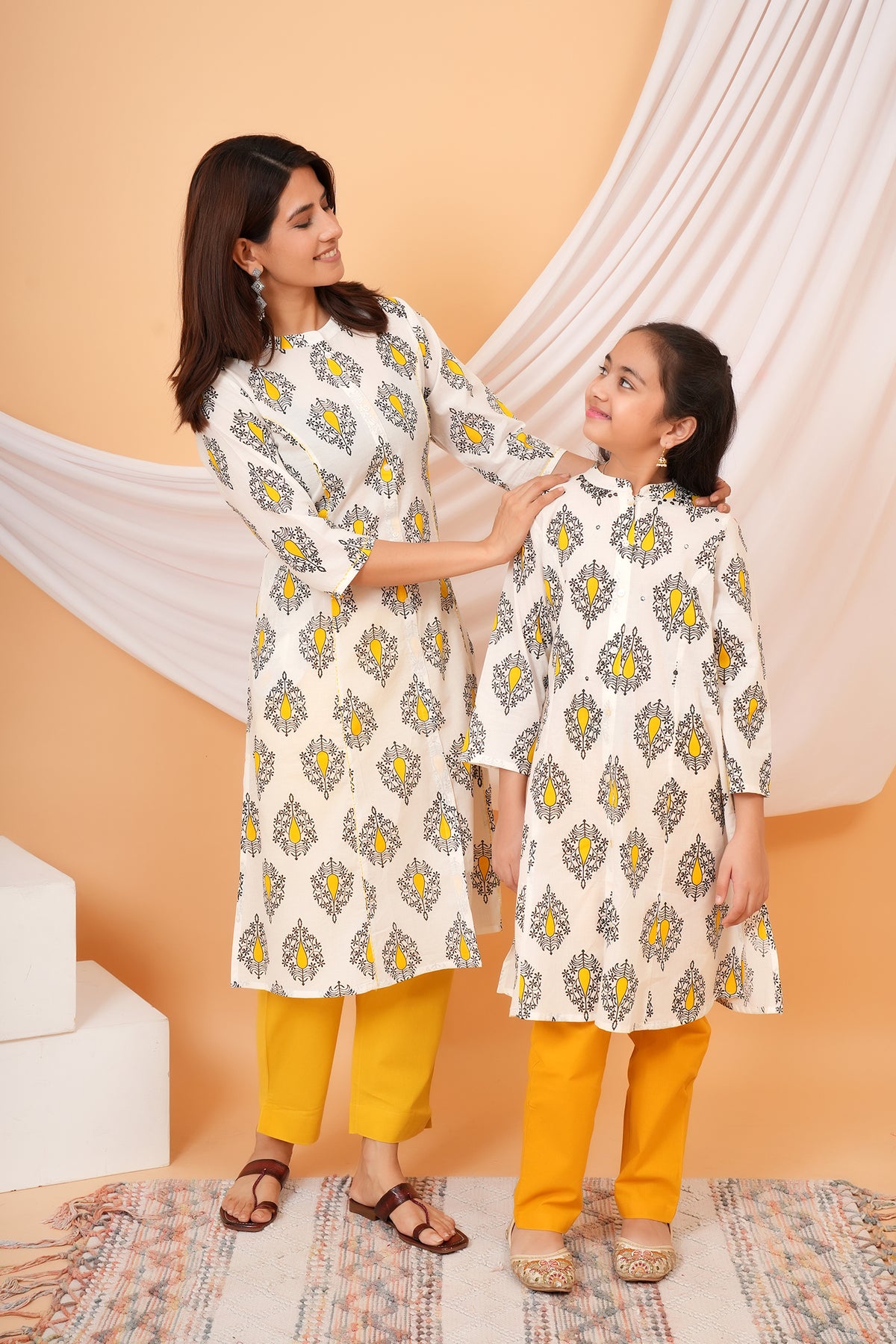Maa and Beti in matching white kurtis with yellow buta print