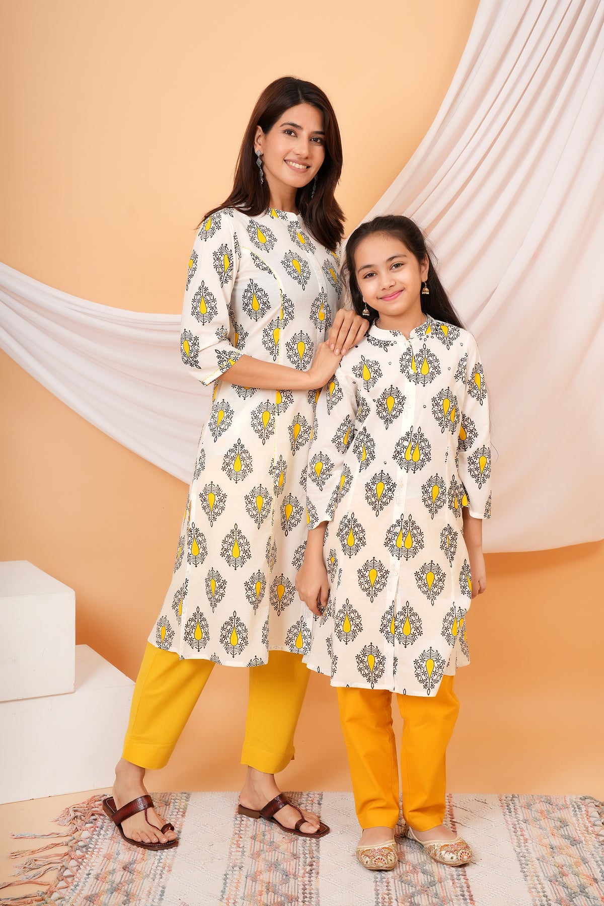 Maa and Beti in matching white kurtis with yellow buta print