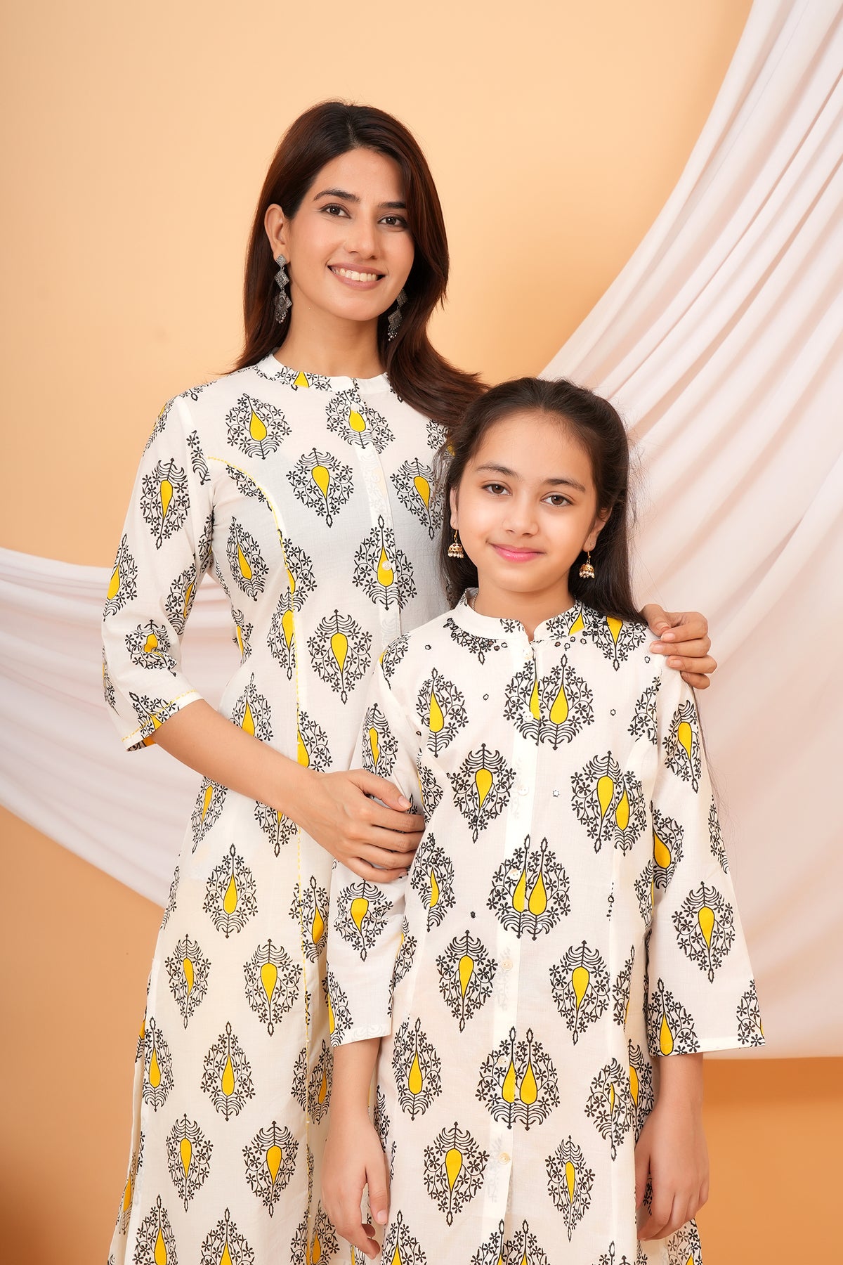 Maa and Beti in matching white kurtis with yellow buta print