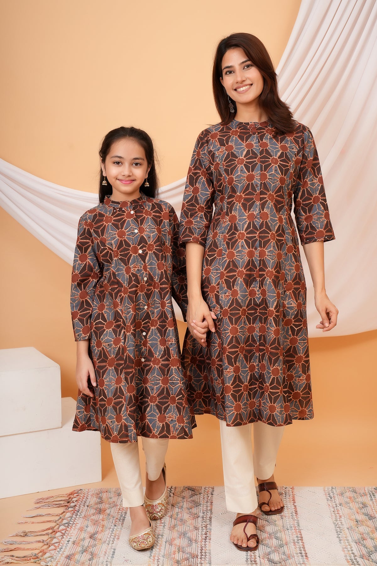 Mother and daughter in matching rust brown geometric floral kurtis