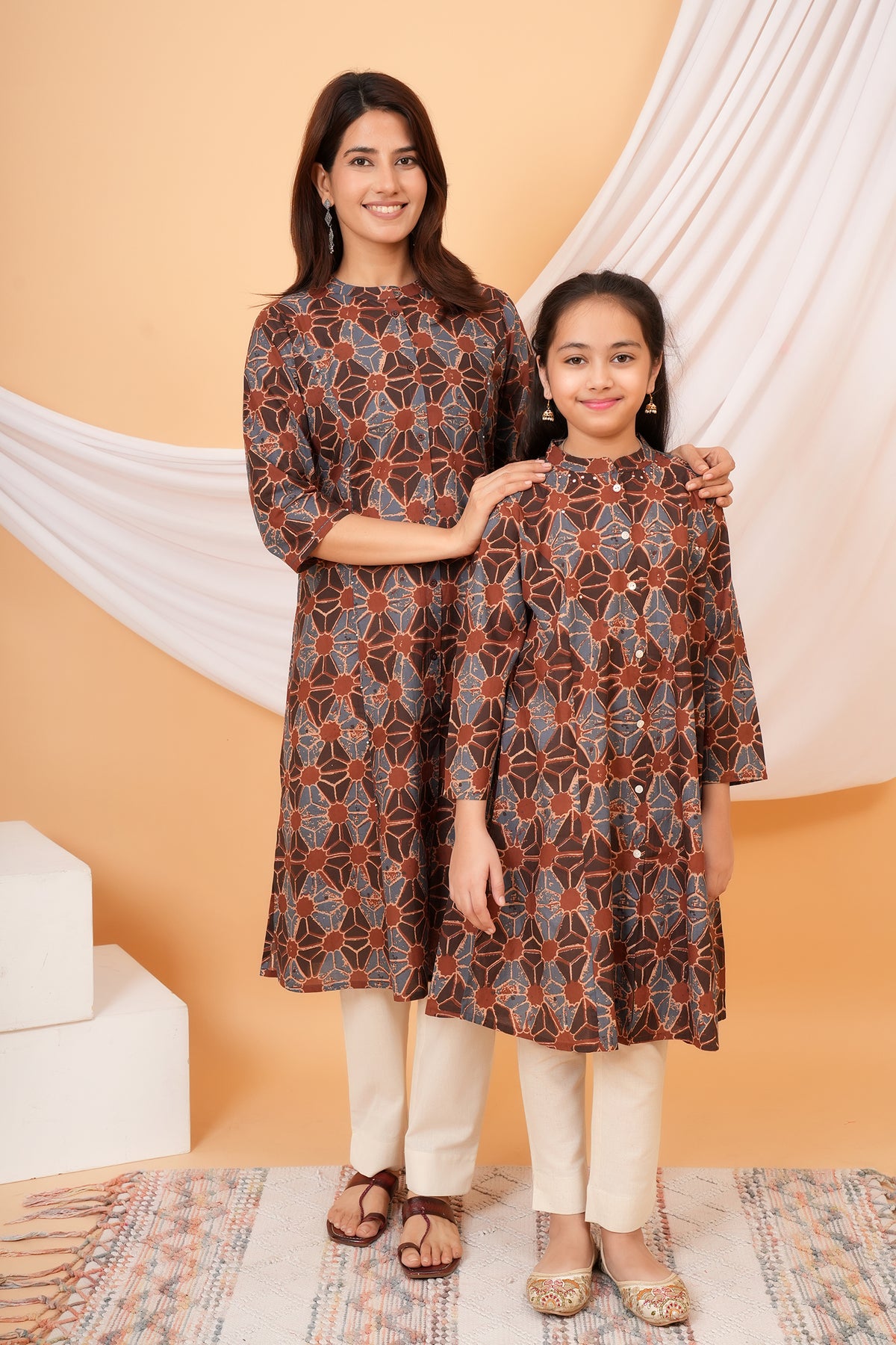 Mother and daughter posing together in rust brown kurtis
