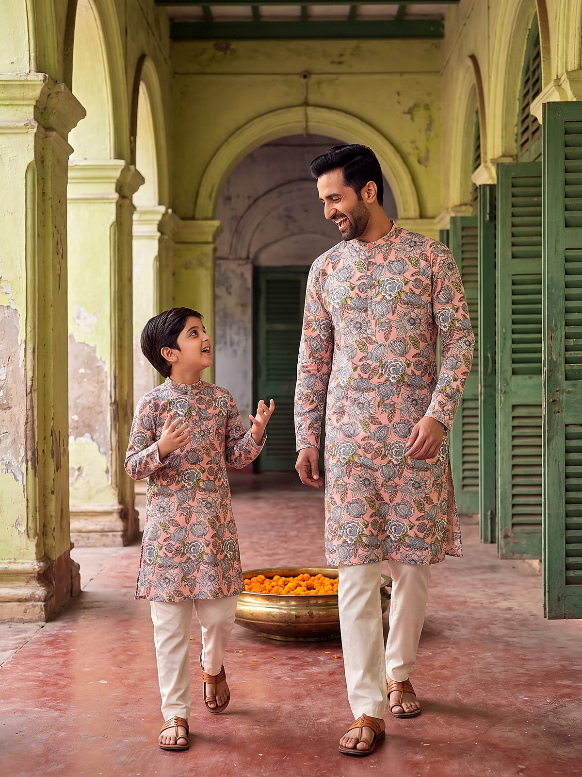 Father and son candid in pink floral kurtas
