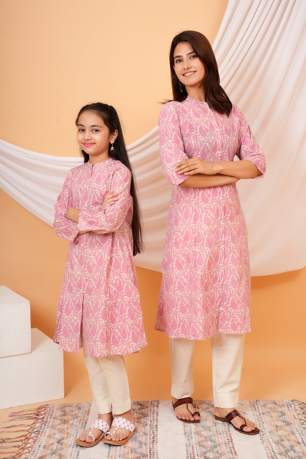 Mother and daughter posing with arms crossed in matching kurtis