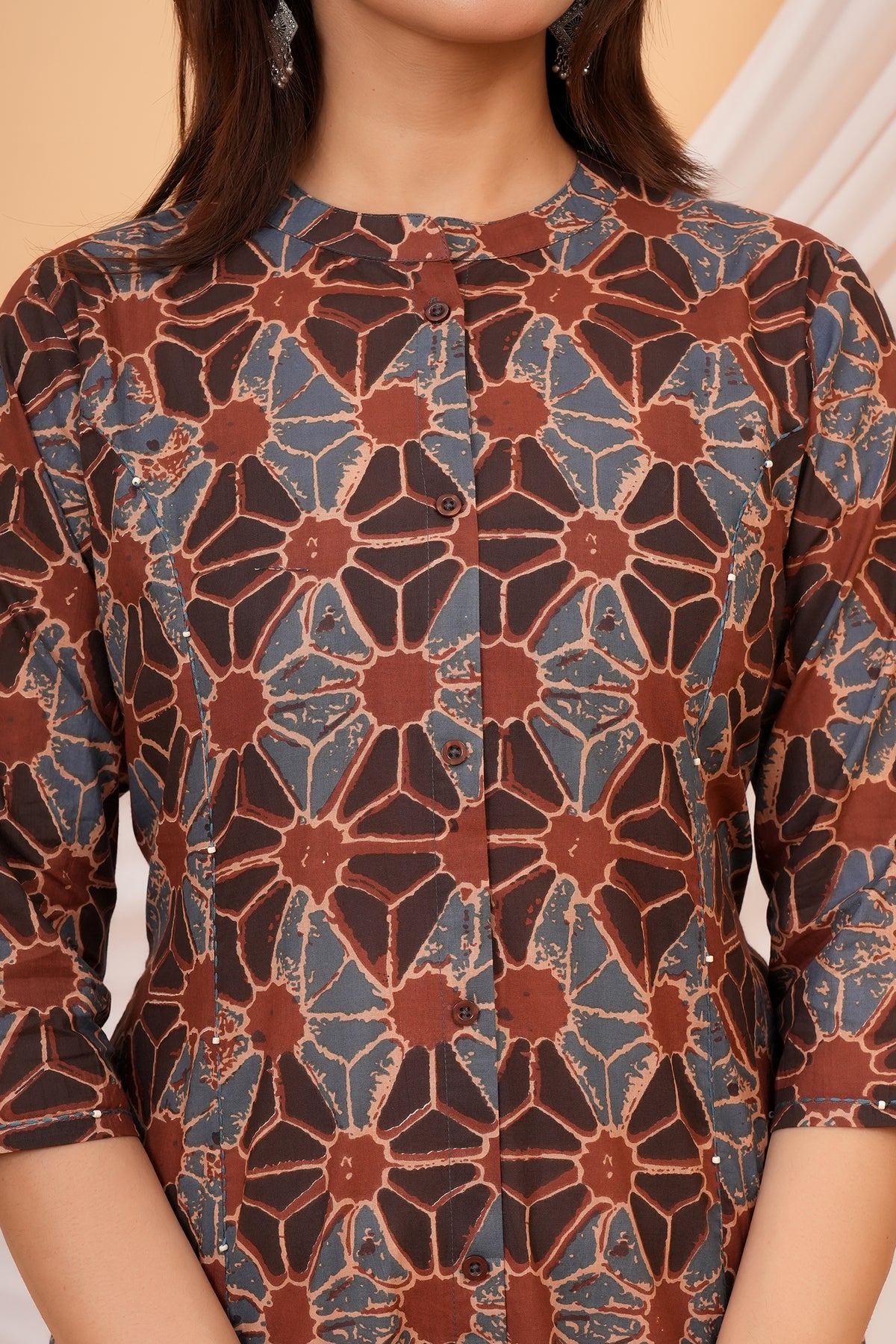 Close-up of mandarin collar, buttons and geometric floral print