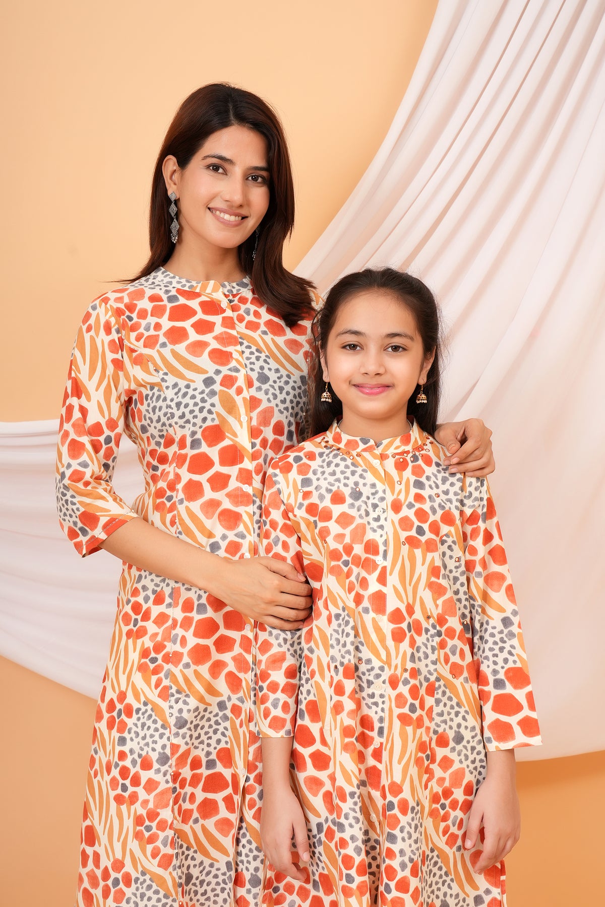 Maa and Beti in matching orange abstract animal printed kurtis