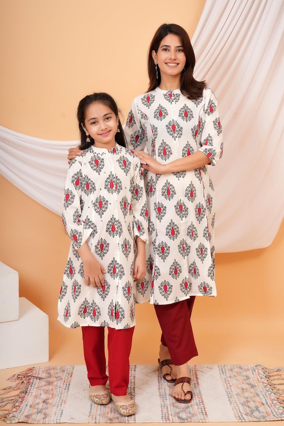 Maa and Beti in matching white kurtis with red buta print