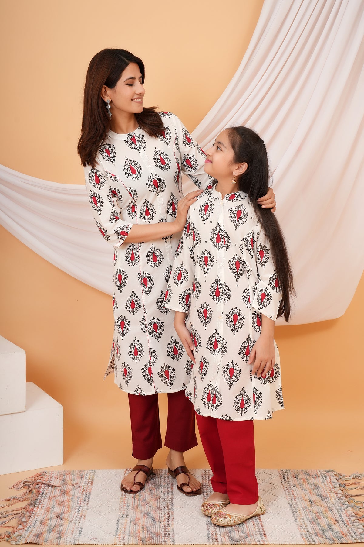 Maa and Beti in matching white kurtis with red buta print