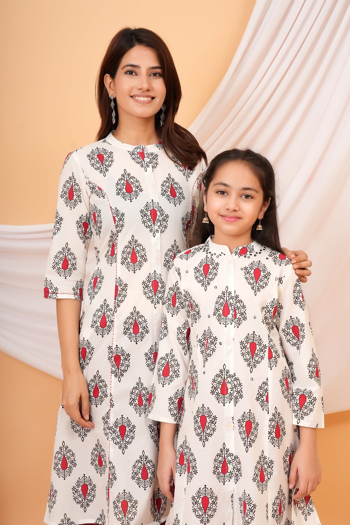 Maa and Beti in matching white kurtis with red buta print