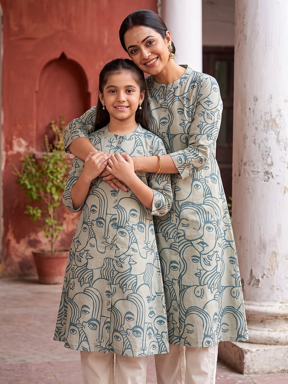 Mother hugging daughter in matching sky blue face art kurtis